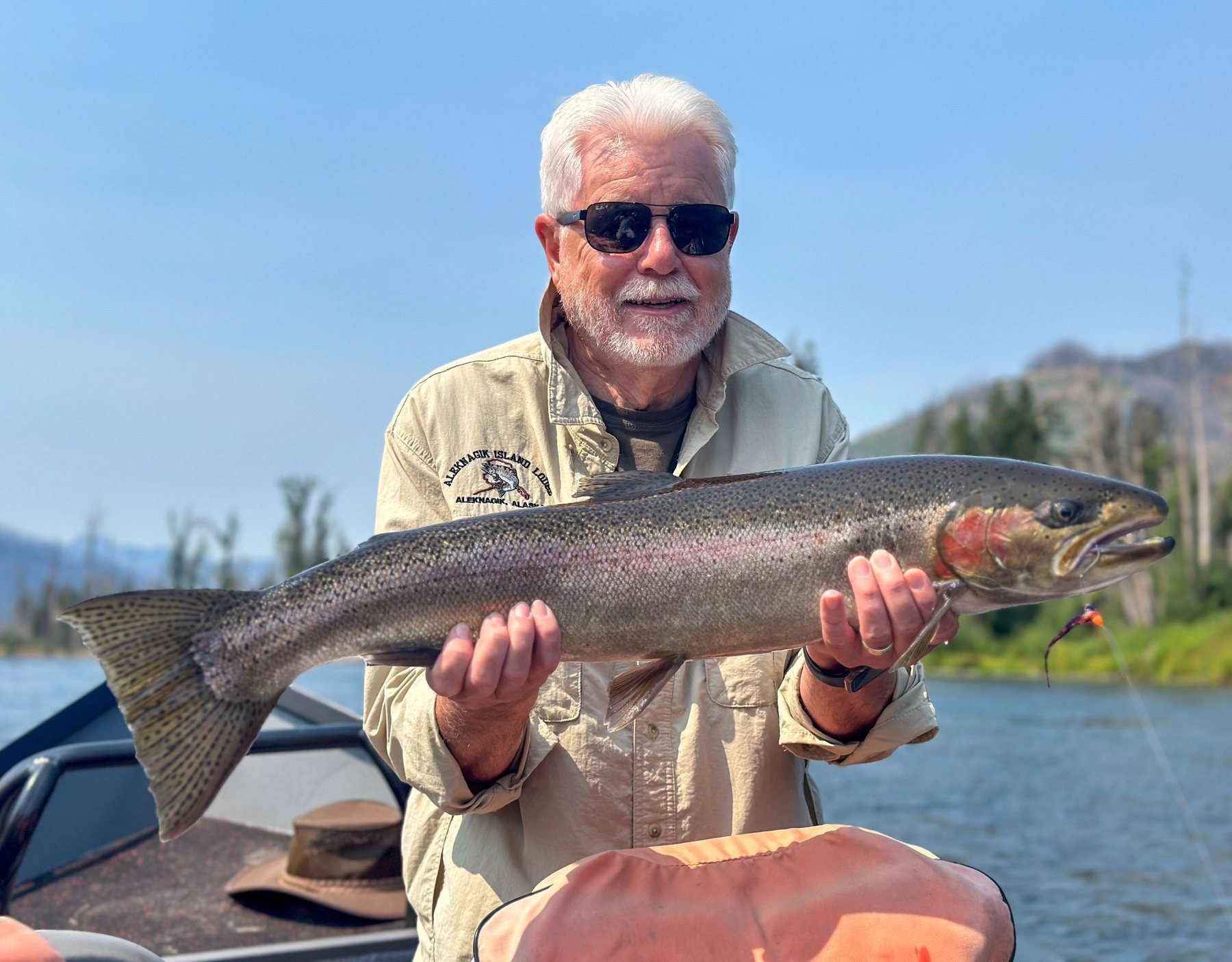 Angler holding a full steelhead on the river
