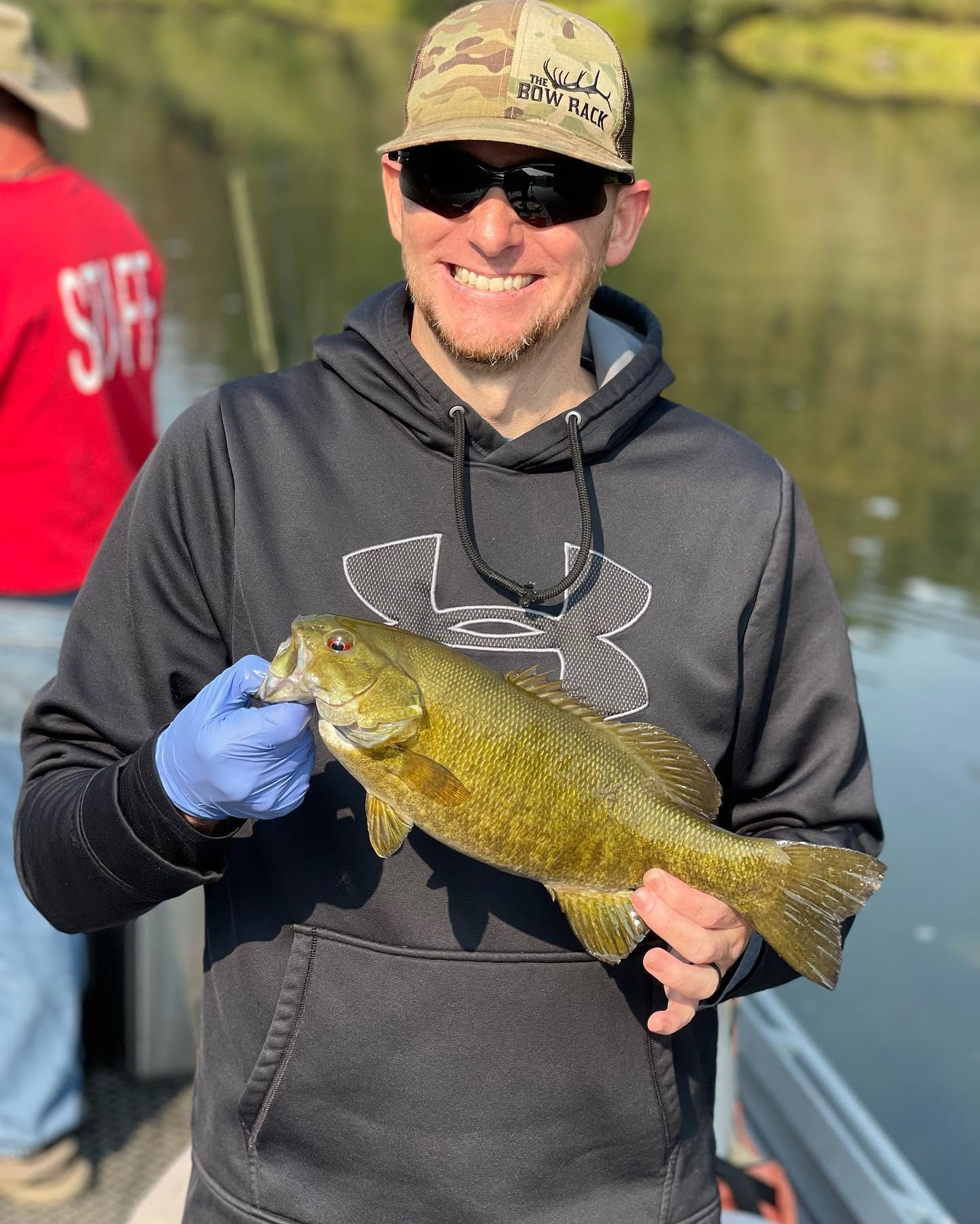 Angler holding a smallmouth bass on an early-season sled trip